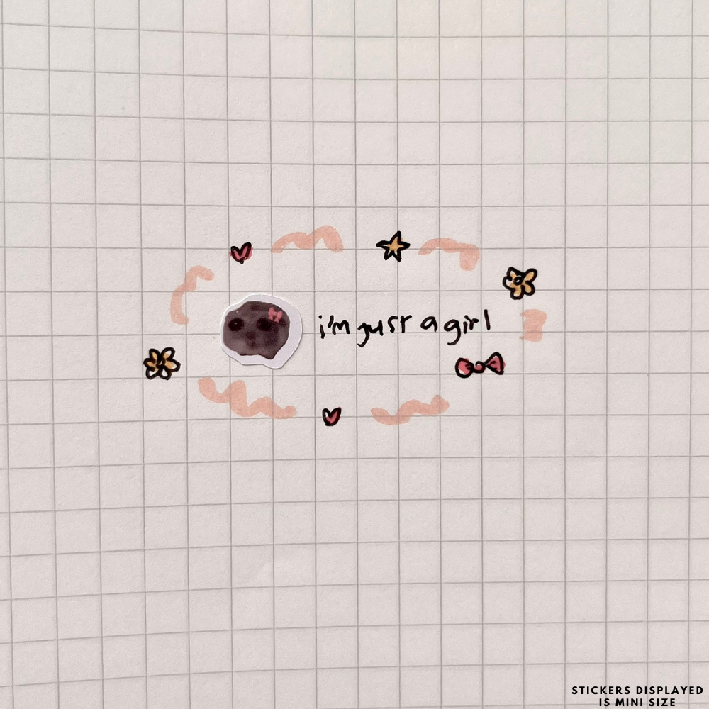 Mini cat face sticker with a pink bow on grid paper beside the words I'm just a girl surrounded by drawn hearts and flowers.