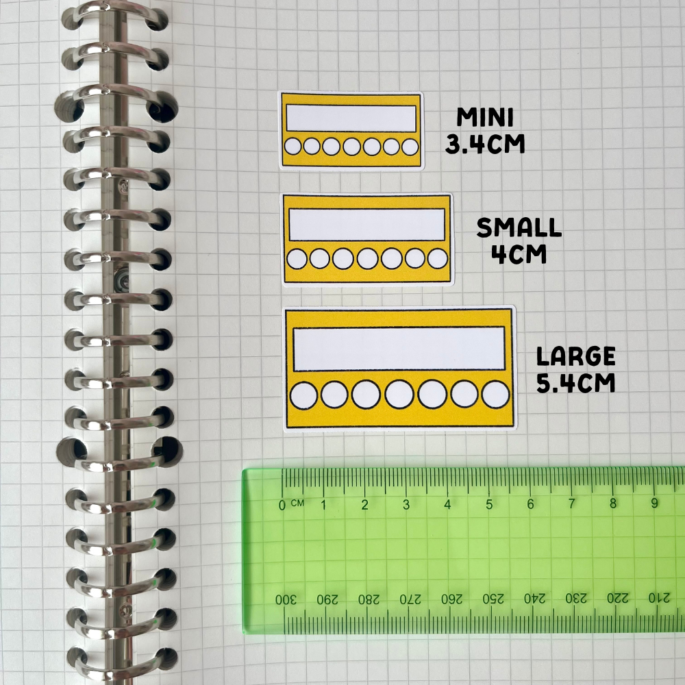 a spiral notebook with a ruler and three different sizes of circles drawn on it, indicating the sizes of the circles in centimeters.